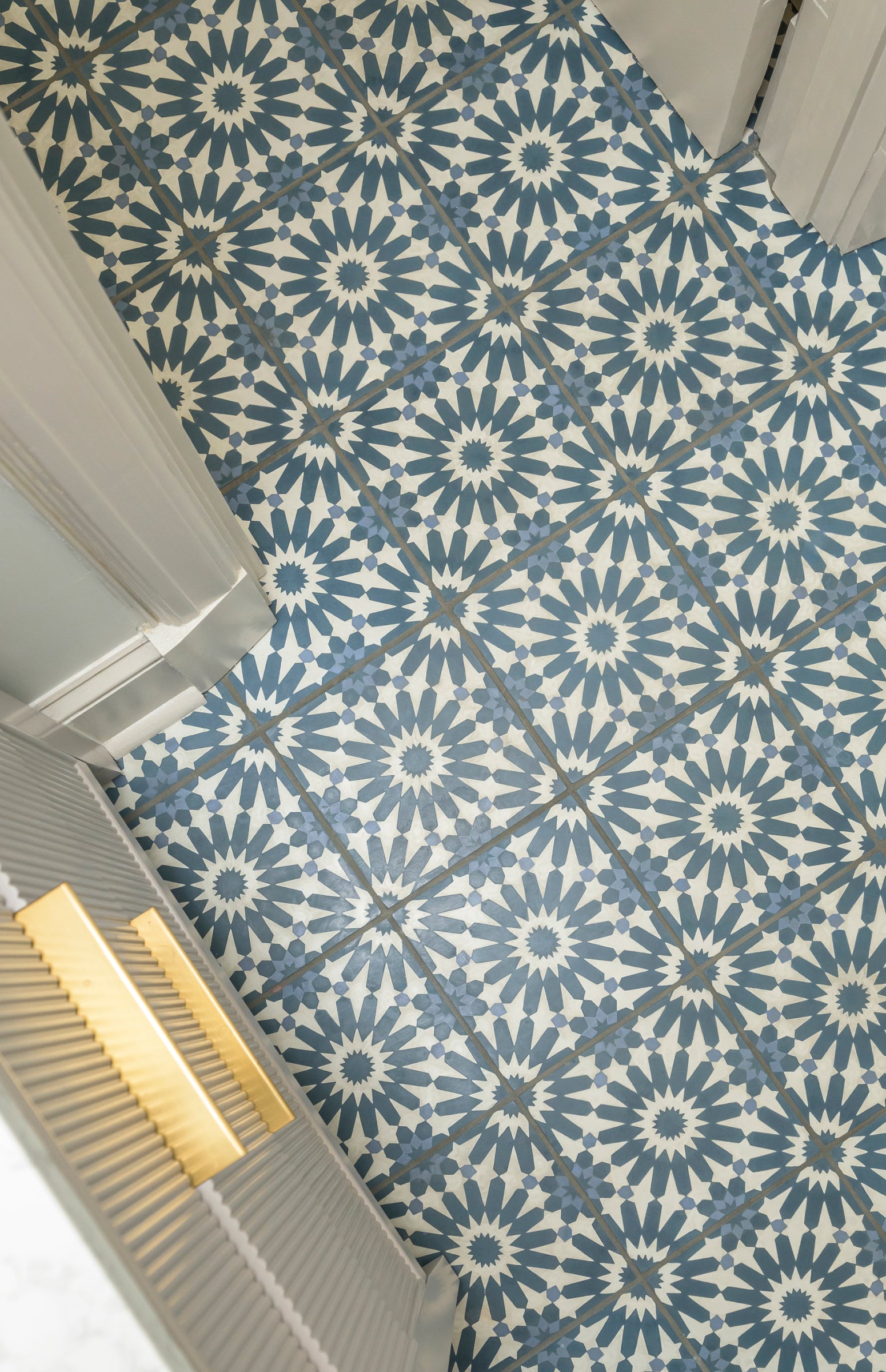 Patterned blue and white tiles on a floor with a light gray baseboard.
