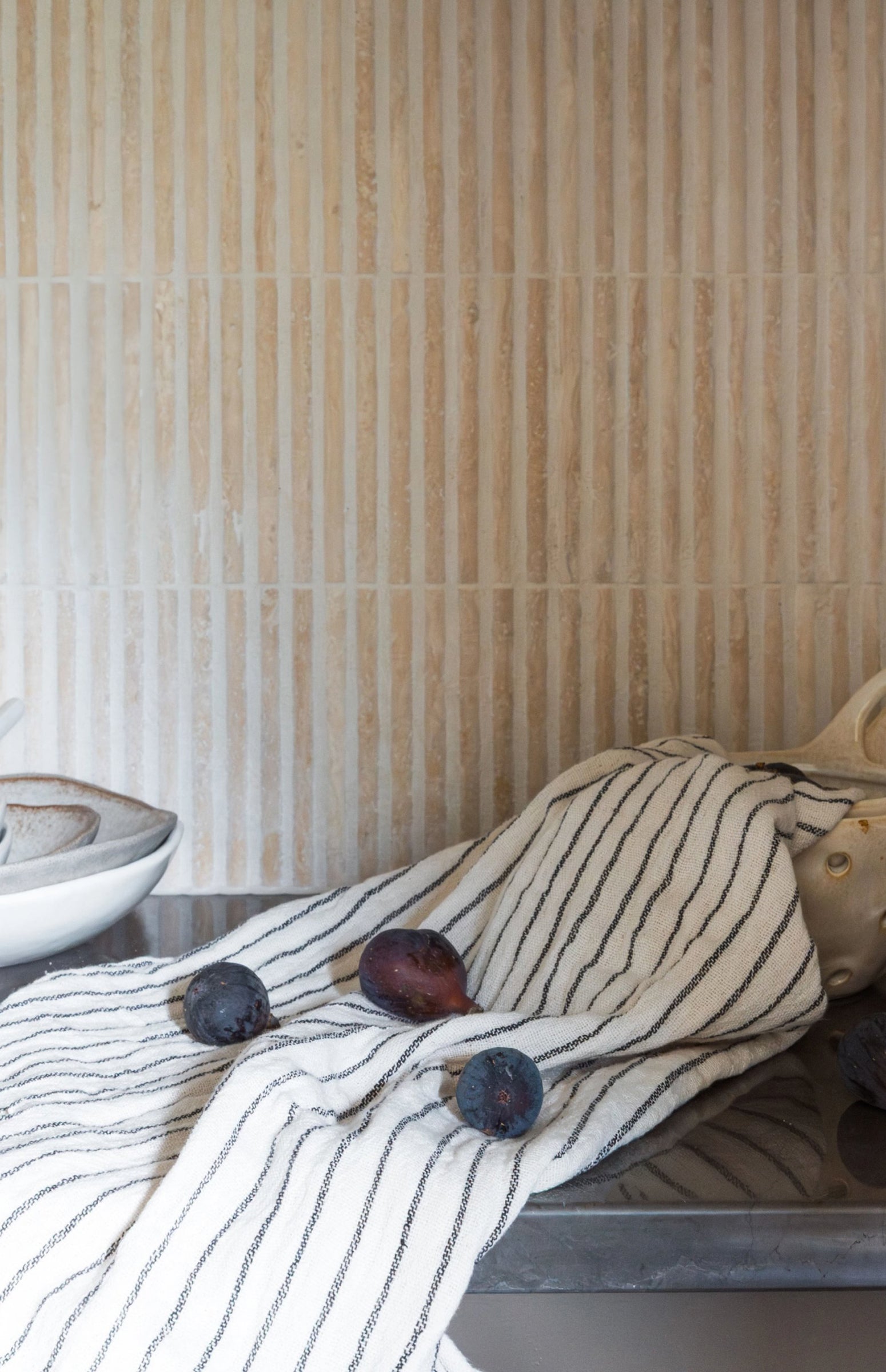 Striped fabric with fruits and a bowl on a neutral background