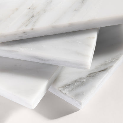 close up angle of White casablanca carrara marble tiles on a light gray background