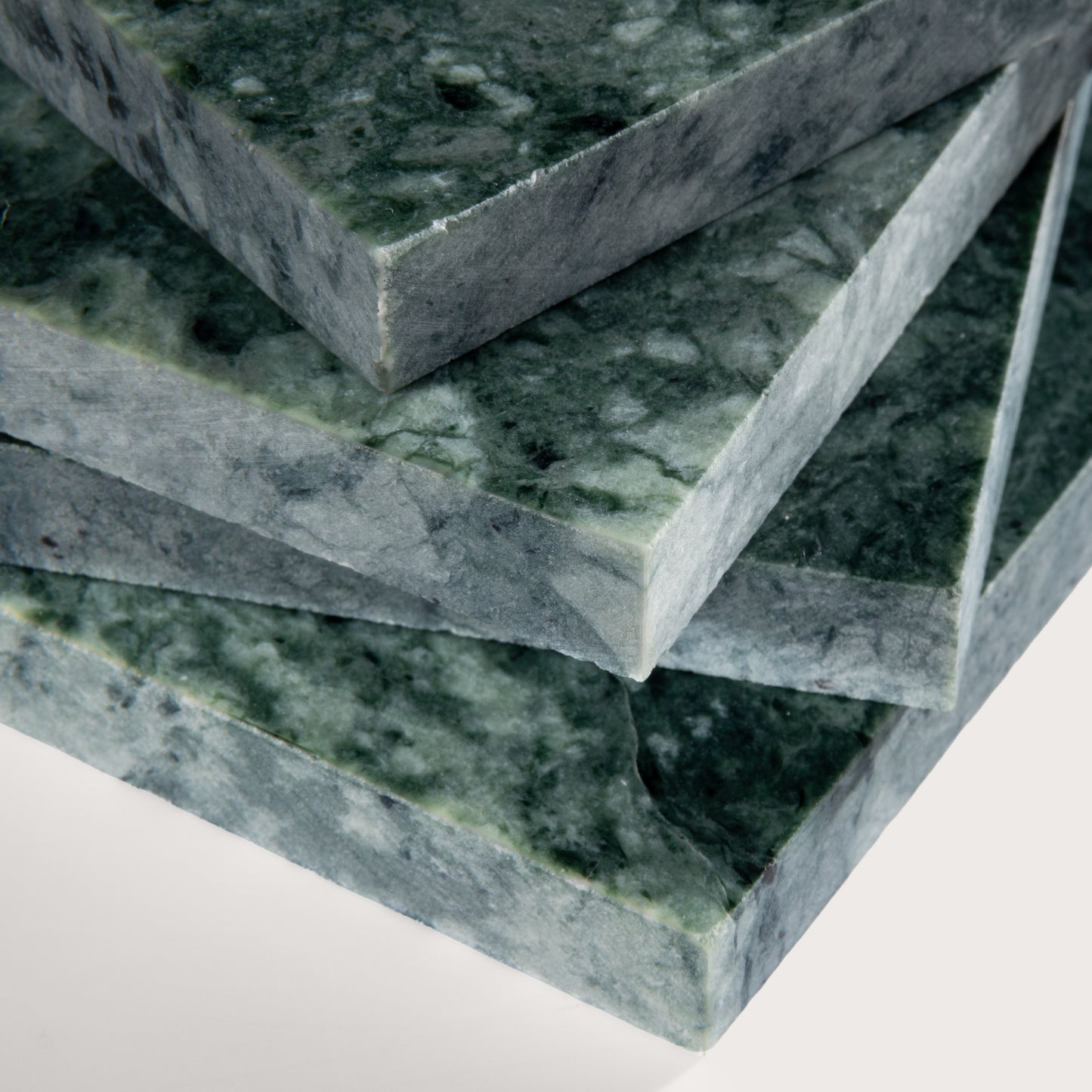 Stack of green marble slabs on a white background