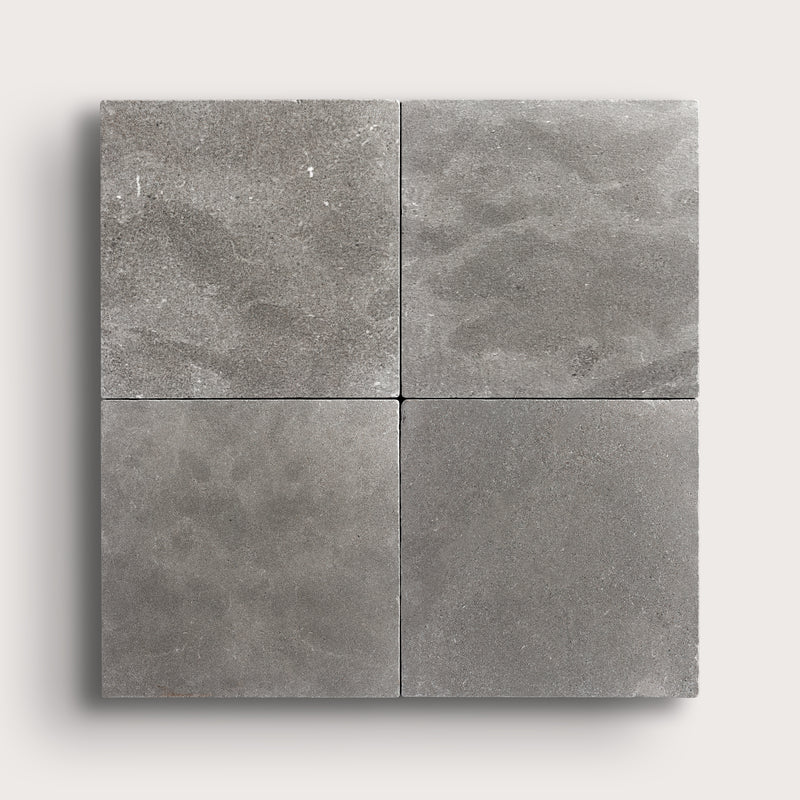 grey square limestone tile in grid pattern on a light grey background